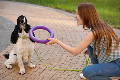 Woman playing with her English Springer Spaniel dog outdoors