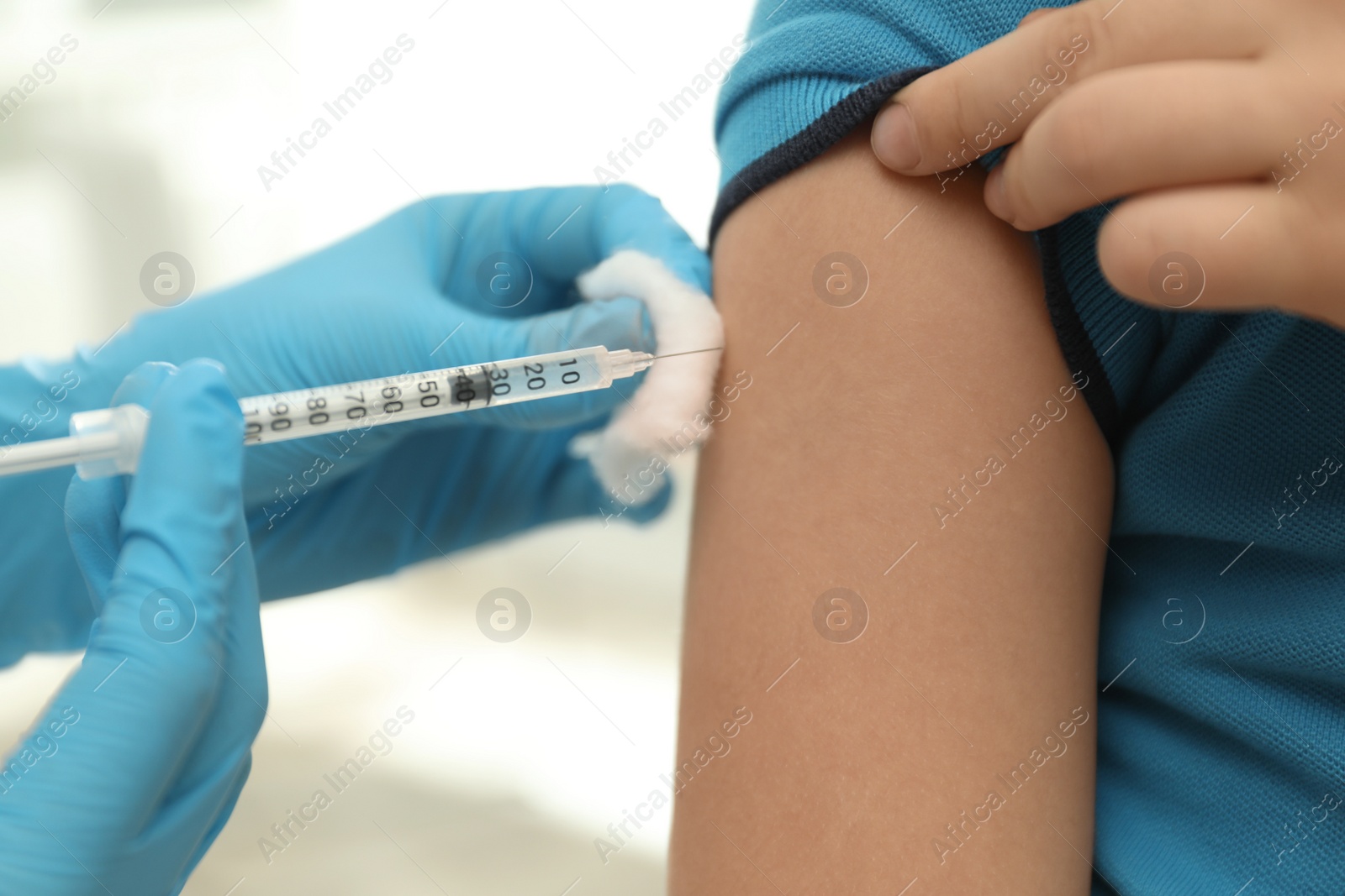 Photo of Doctor vaccinating little child in clinic, closeup