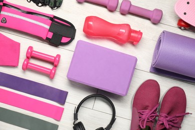 Different sports equipment on white wooden table, flat lay