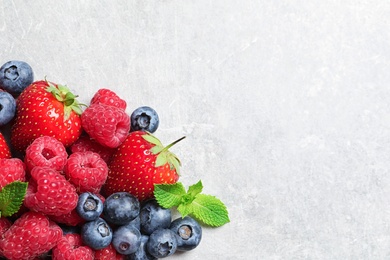 Photo of Raspberries, strawberries and blueberries on table, top view