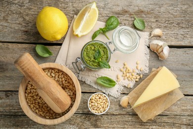 Photo of Delicious pesto sauce and ingredients on wooden table, flat lay