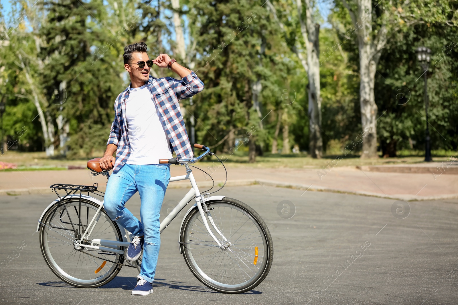 Photo of Handsome young hipster man with bicycle outdoors