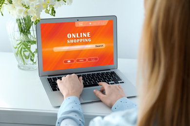 Woman using laptop for online shopping indoors, closeup