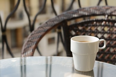 Photo of Ceramic cup of aromatic coffee on glass table outdoors, space for text. Good morning
