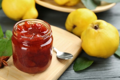 Photo of Delicious quince jam on grey wooden table, closeup