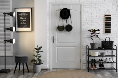 Hallway interior with stylish furniture, shoes and plants