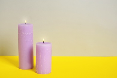 Photo of Decorative candles on table against light background