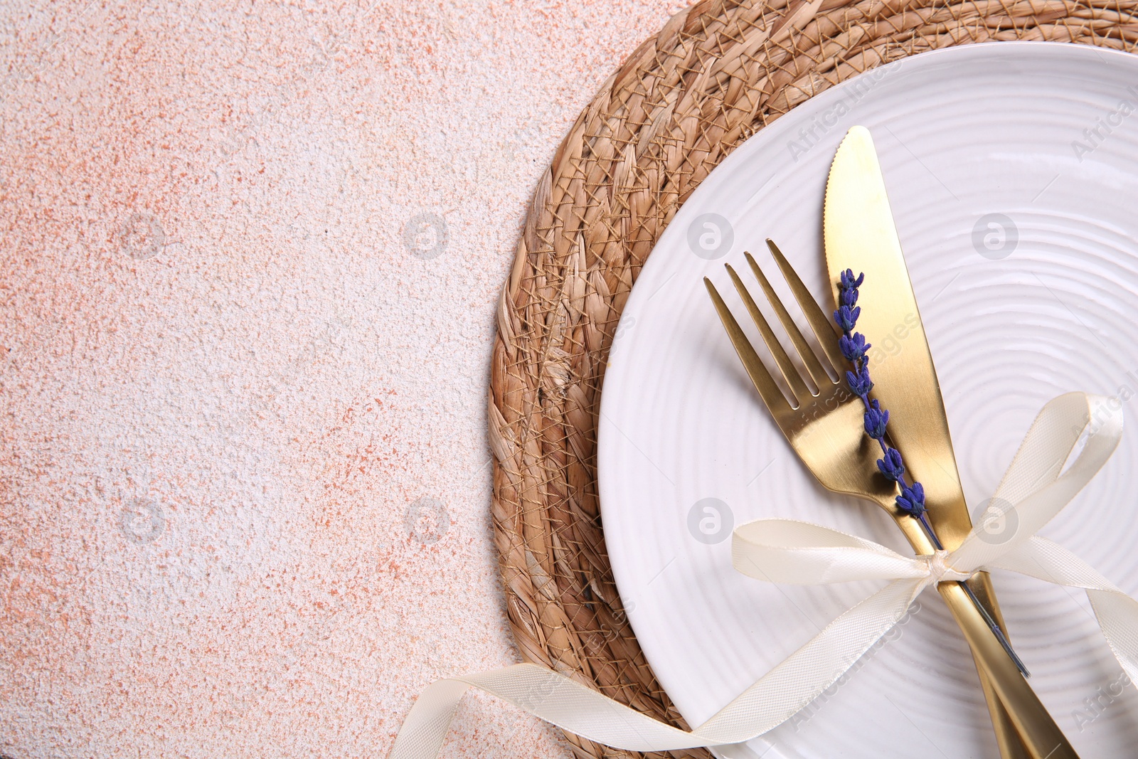 Photo of Cutlery, plate and preserved lavender flower on color textured table, top view. Space for text