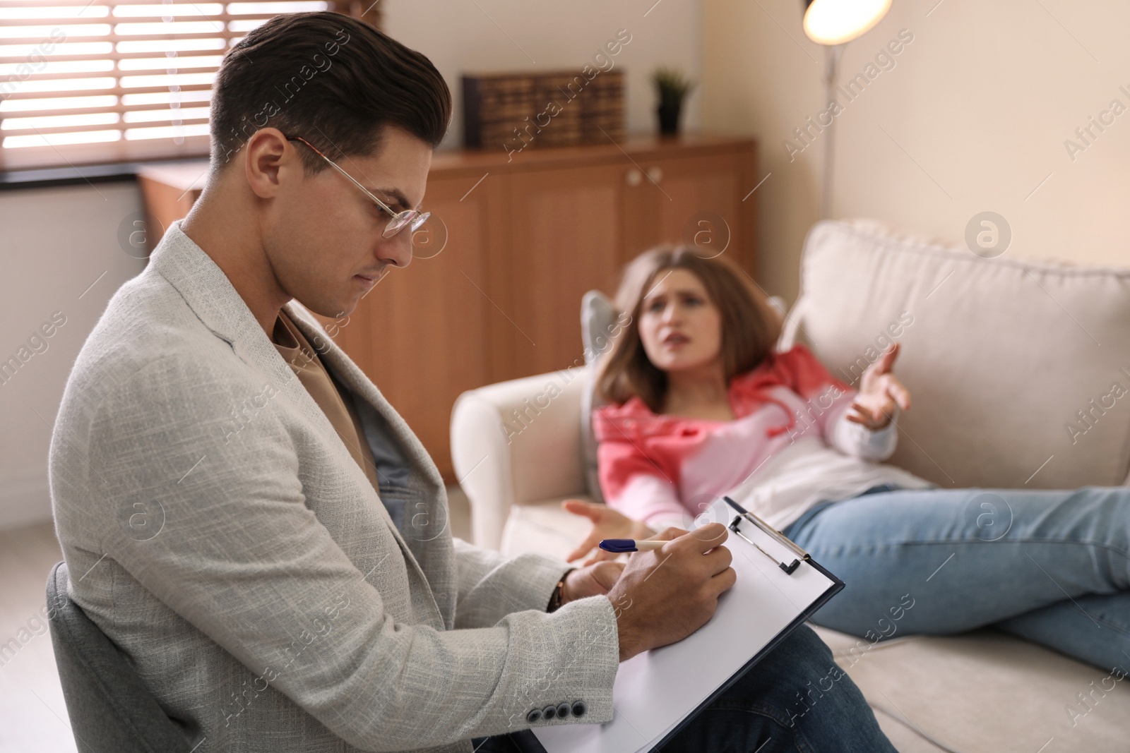 Photo of Professional psychotherapist working with patient in office