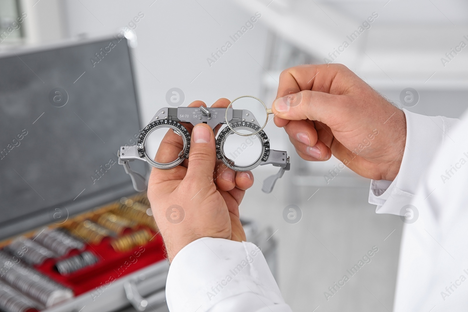 Photo of Children doctor holding trial frame and lens on blurred background