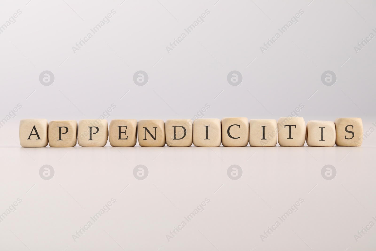 Photo of Word Appendicitis made of wooden cubes with letters on light background