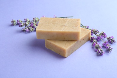 Photo of Hand made soap bars with lavender flowers on violet background