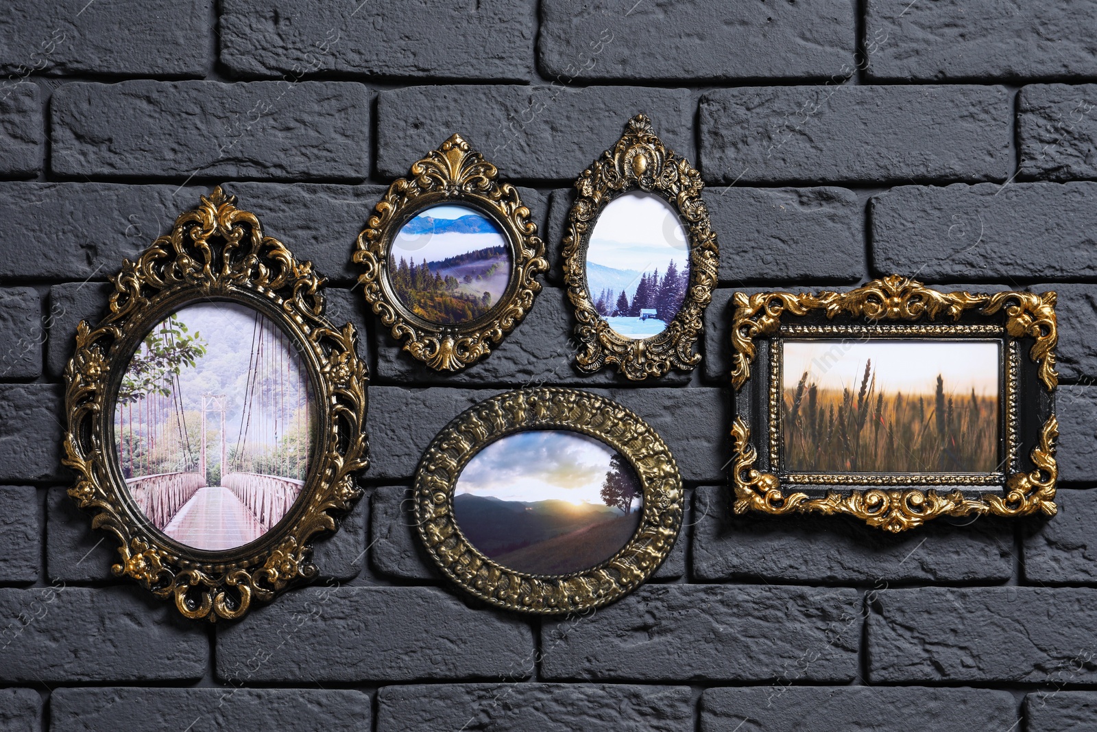 Photo of Vintage frames with photos of beautiful landscapes hanging on dark brick wall