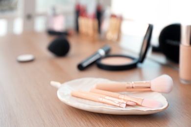 Photo of Brushes on dressing table in makeup room, closeup