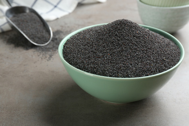 Poppy seeds in bowl on grey table