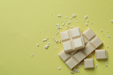 Photo of Tasty white chocolate on yellow background, flat lay. Space for text