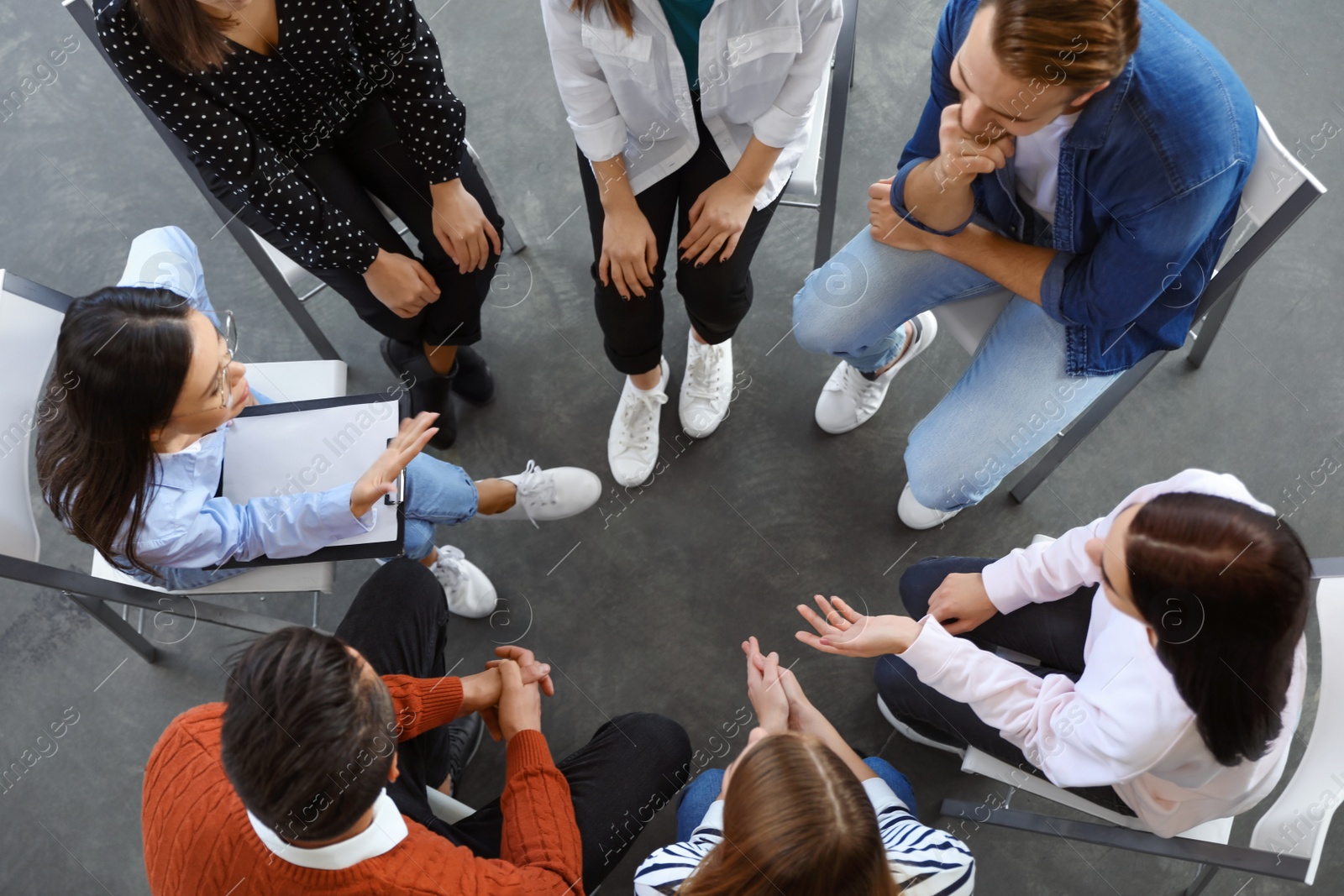 Photo of Psychotherapist working with patients in group therapy session, top view