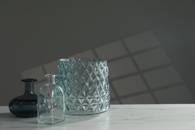 Different stylish vases on white marble table, space for text