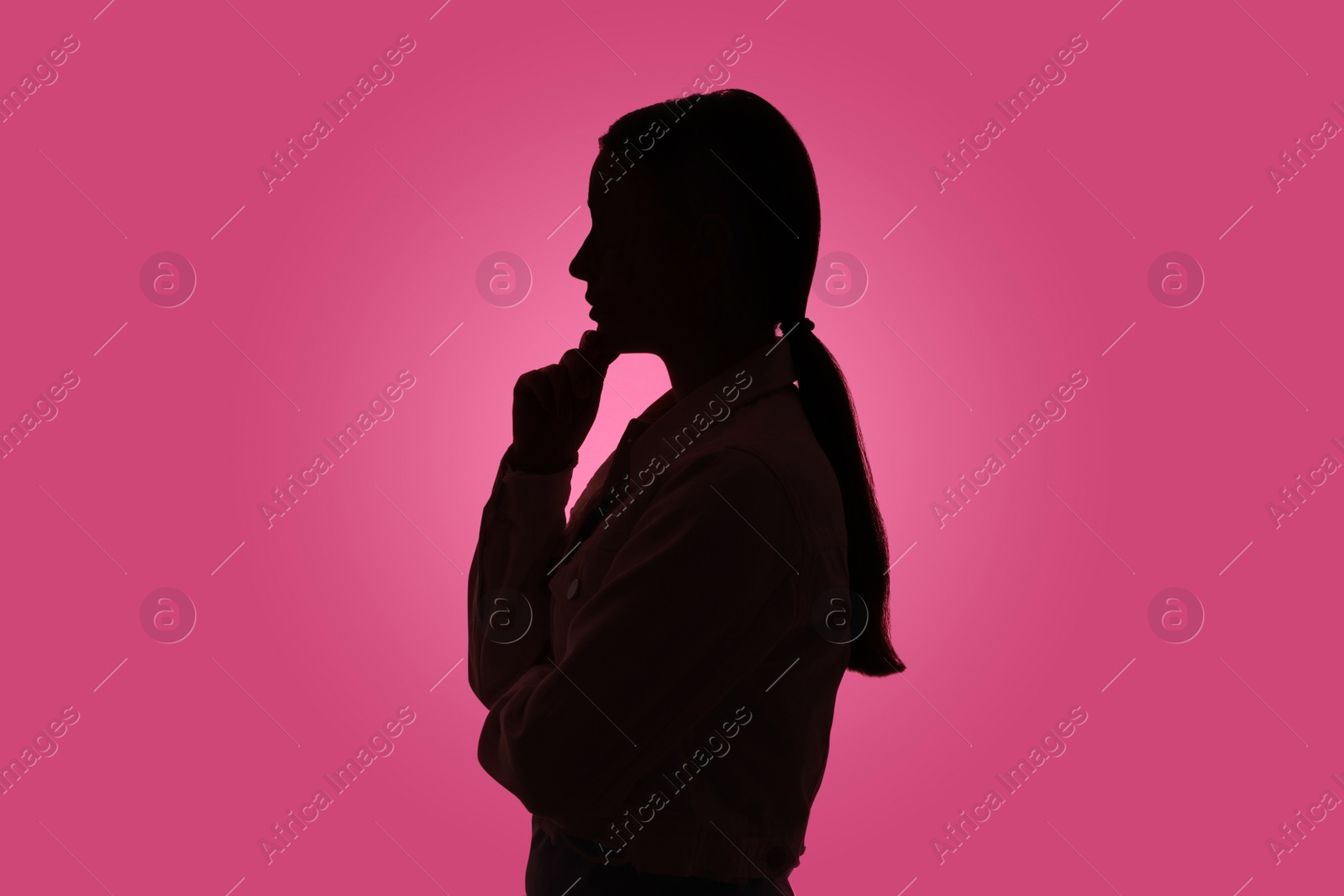 Photo of Silhouette of anonymous woman on pink background