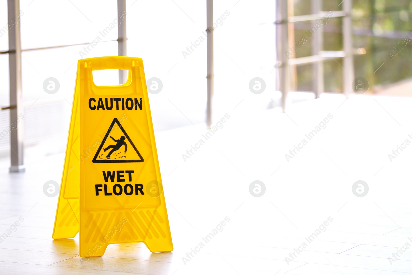 Photo of Safety sign with phrase Caution wet floor, indoors. Cleaning service