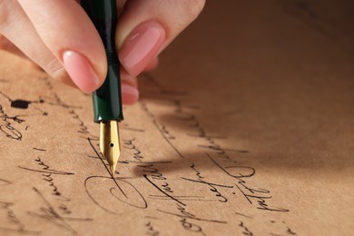 Photo of Woman writing letter with fountain pen, closeup