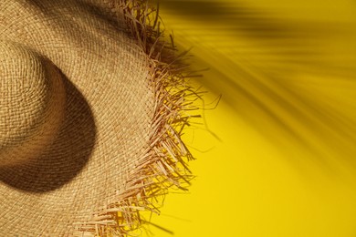 Straw hat on yellow background, top view with space for text. Sun protection