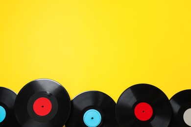 Photo of Vintage vinyl records on yellow background, flat lay