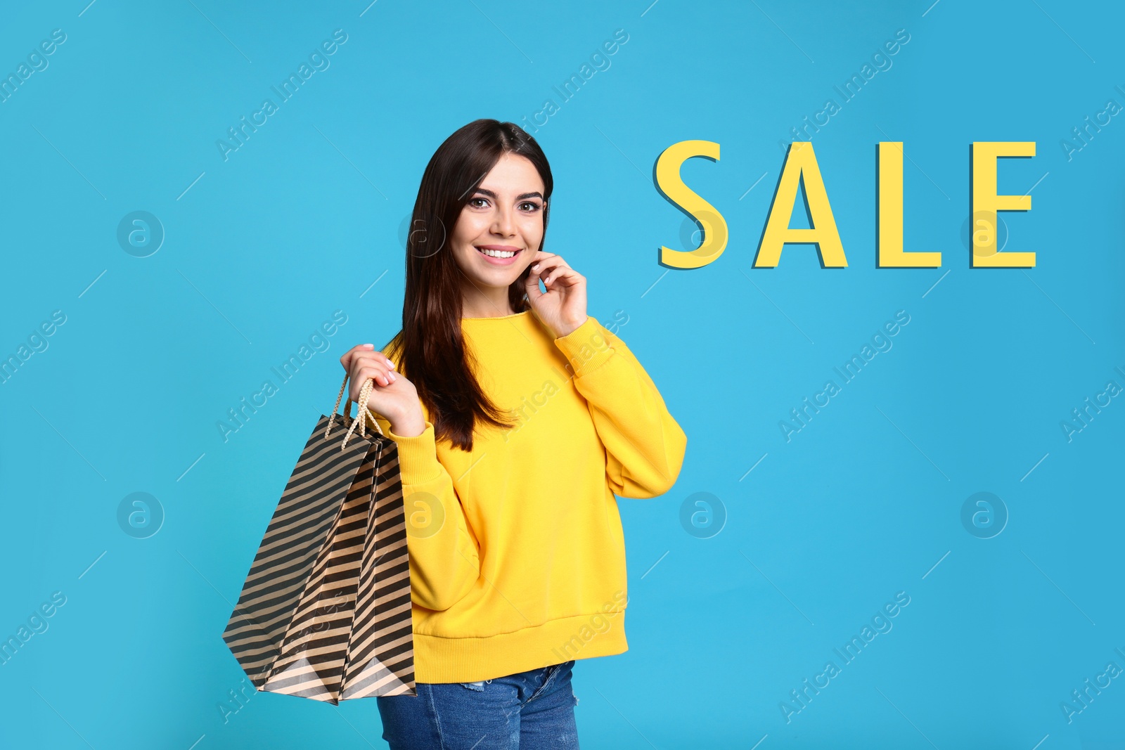 Image of Portrait of young woman with paper bags and word SALE on turquoise background