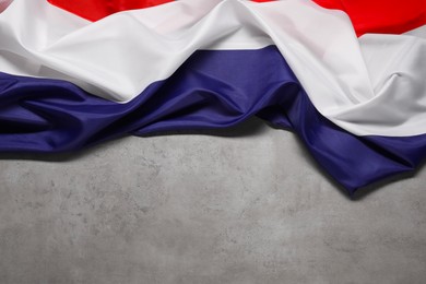 Photo of Flag of Netherlands on gray background, top view. Space for text