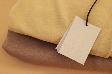 Photo of Garment with cardboard tag, closeup. Space for text