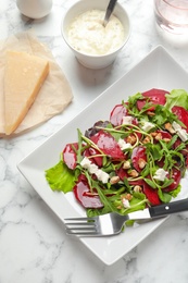 Plate with delicious beet salad on table, top view