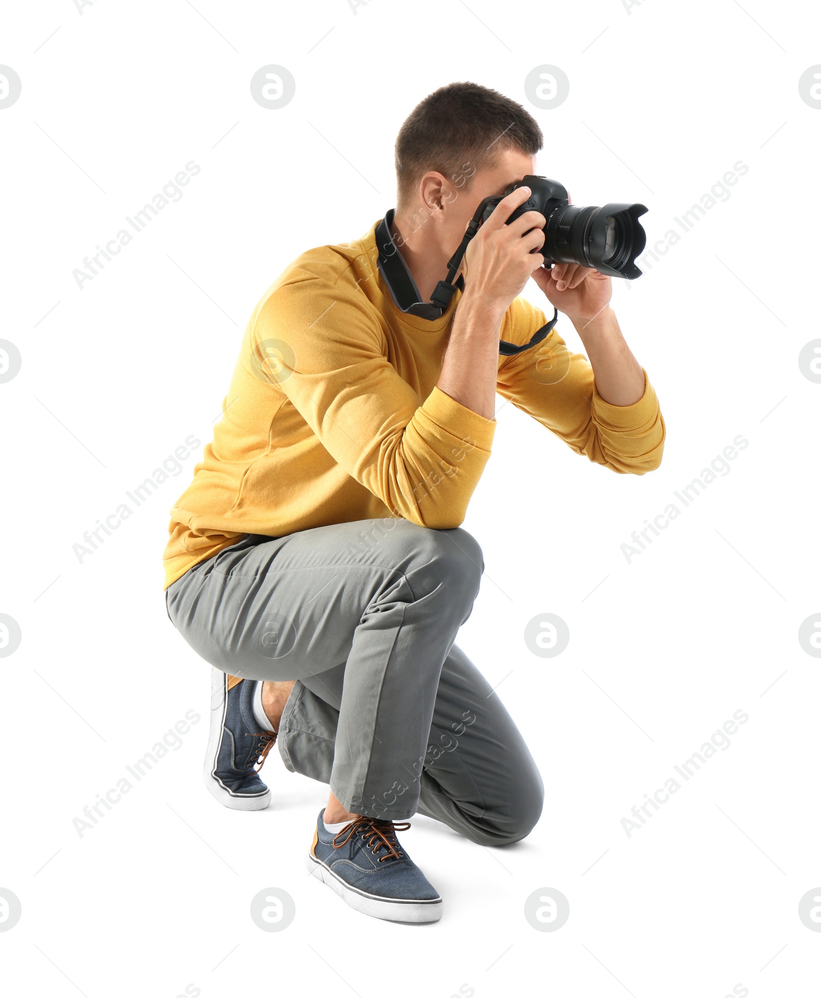 Photo of Young professional photographer taking picture on white background