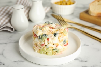Photo of Delicious salad with fresh crab sticks on white marble table