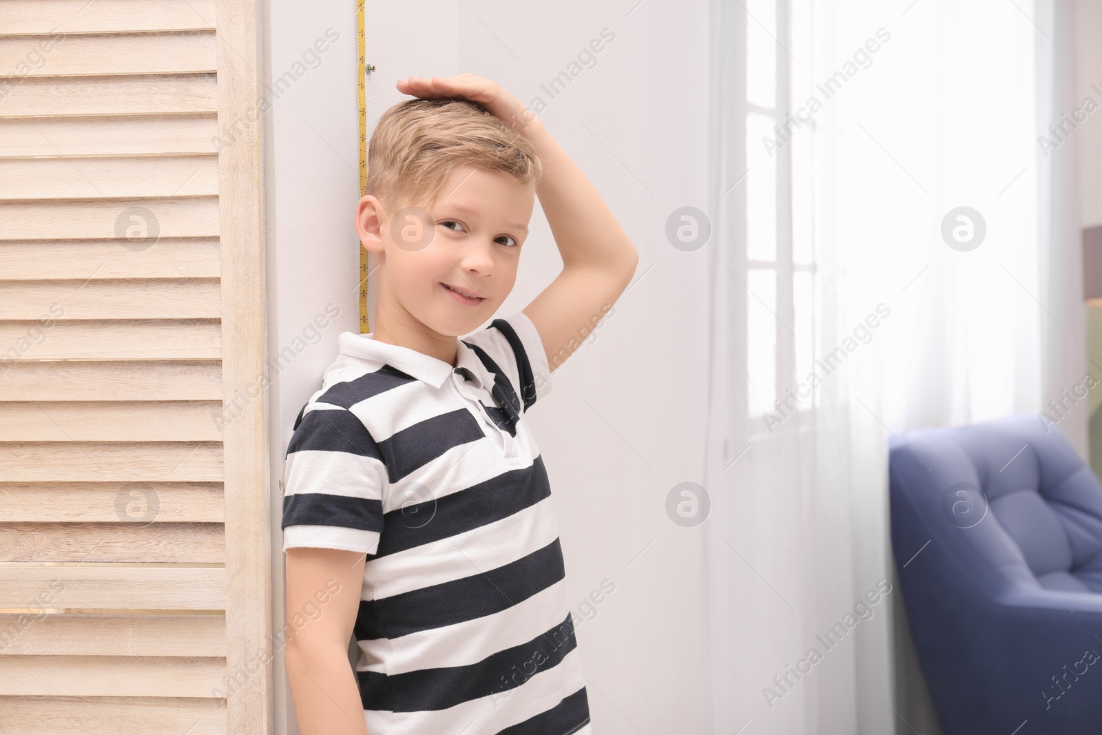 Photo of Little boy measuring his height at home