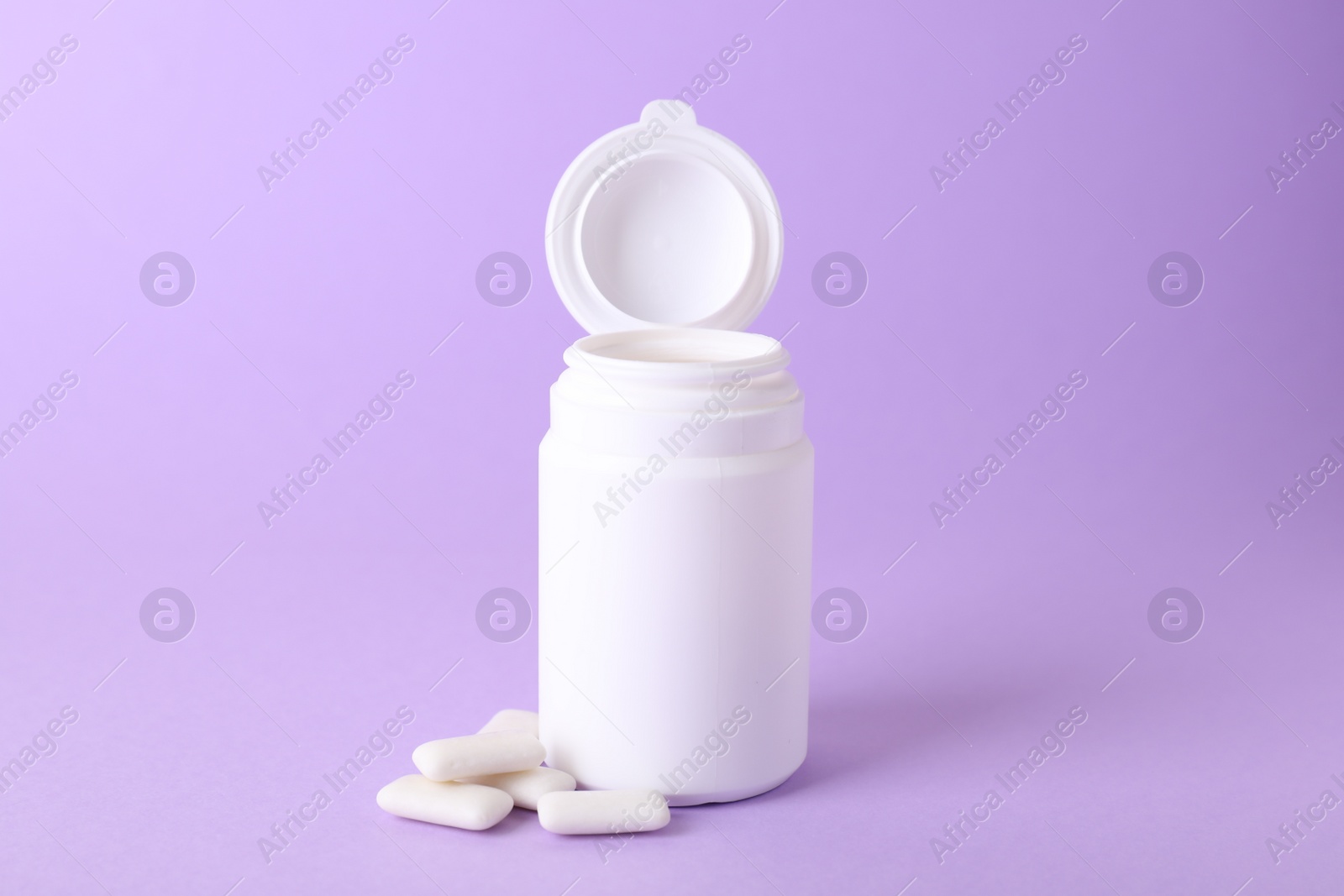 Photo of Jar with chewing gums on lilac background