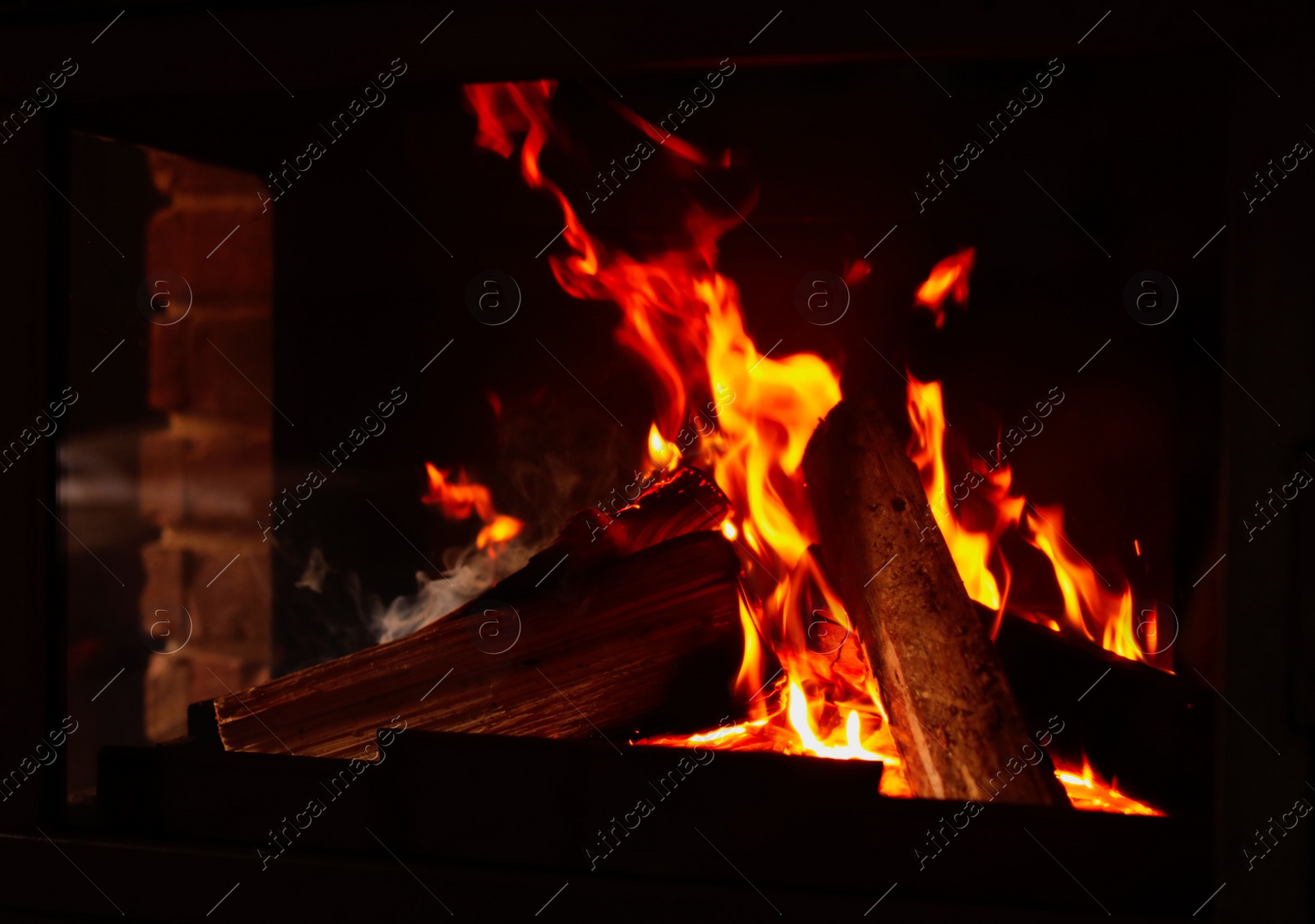 Photo of Fireplace with burning wood, closeup view. Winter vacation