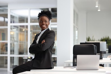 Photo of Happy woman with crossed arms in office, space for text. Lawyer, businesswoman, accountant or manager
