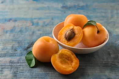 Composition with delicious apricots on blue wooden background