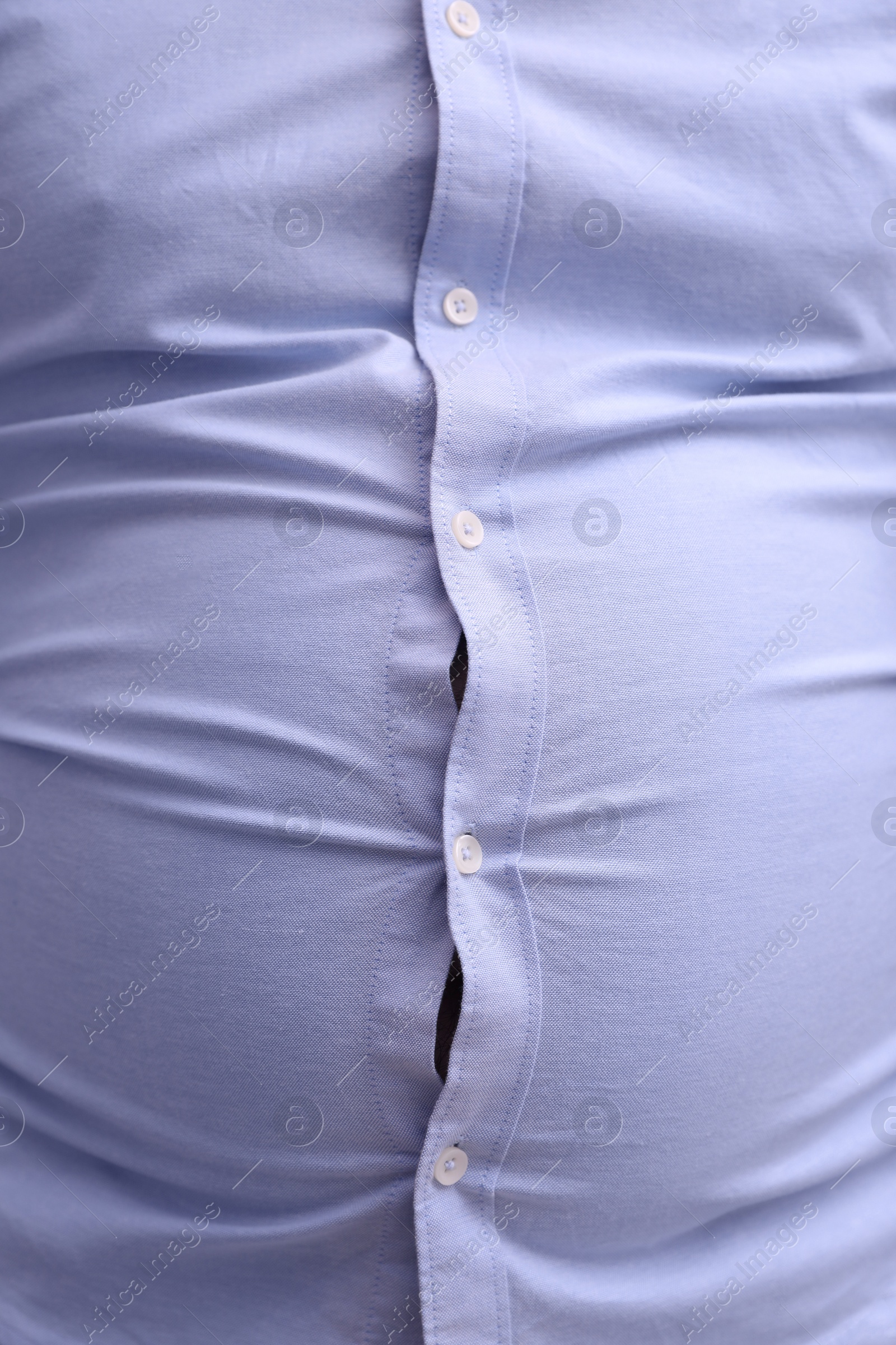 Photo of Man wearing tight shirt, closeup view. Overweight problem