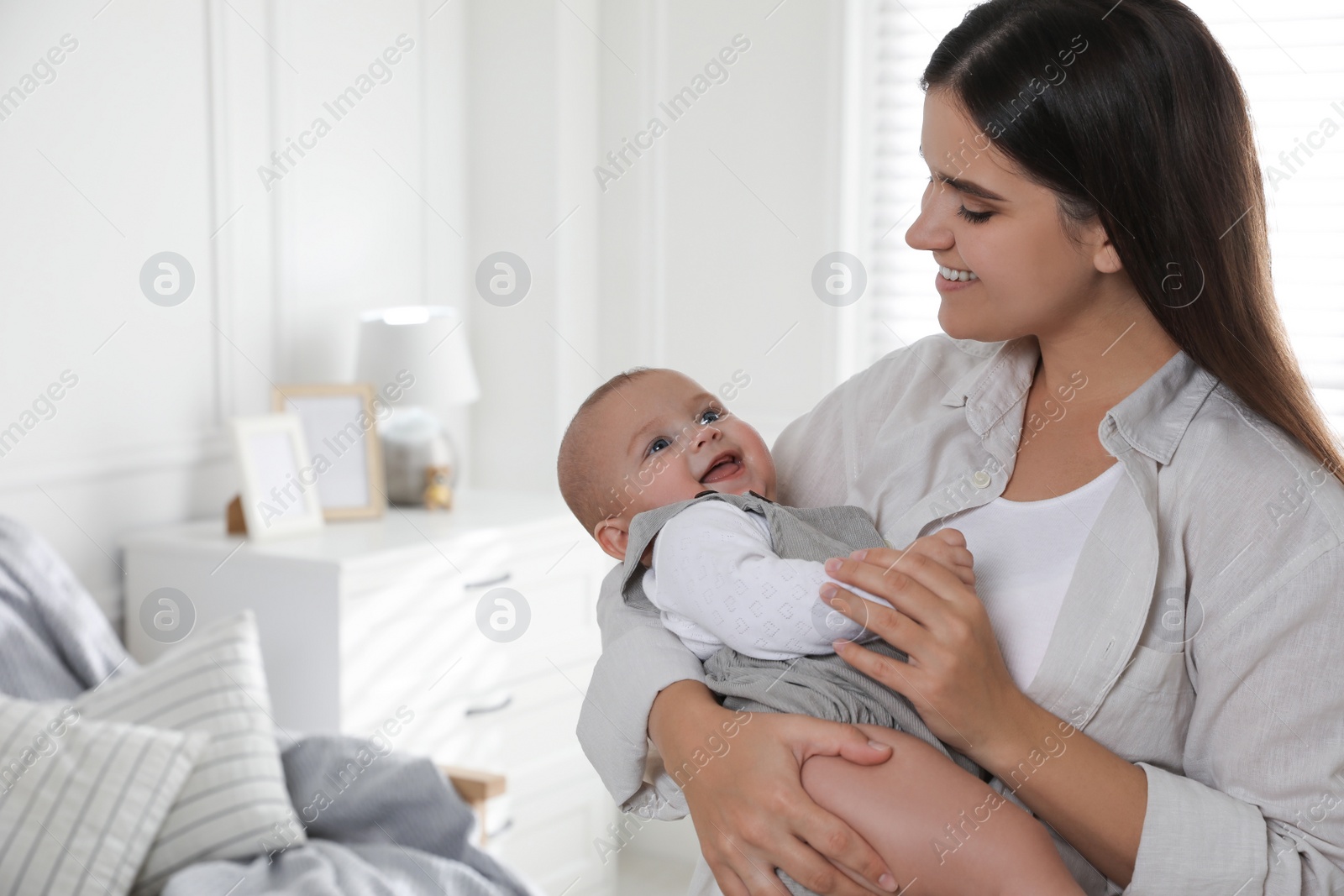 Photo of Young woman with her little baby at home