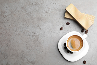 Breakfast with delicious wafers and coffee on grey table, flat lay. Space for text