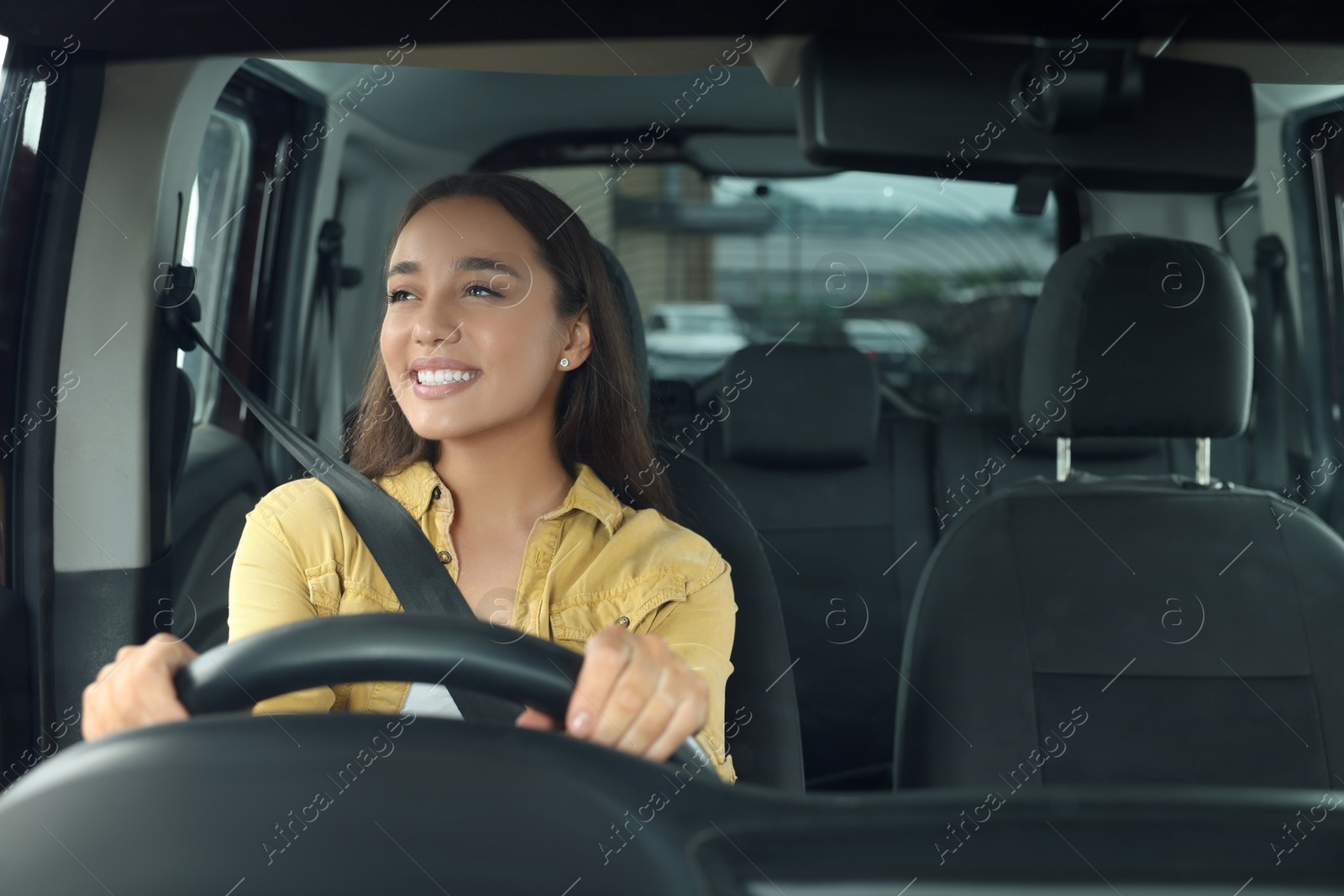 Photo of Listening to radio. Beautiful woman enjoying music in car, view through windshield