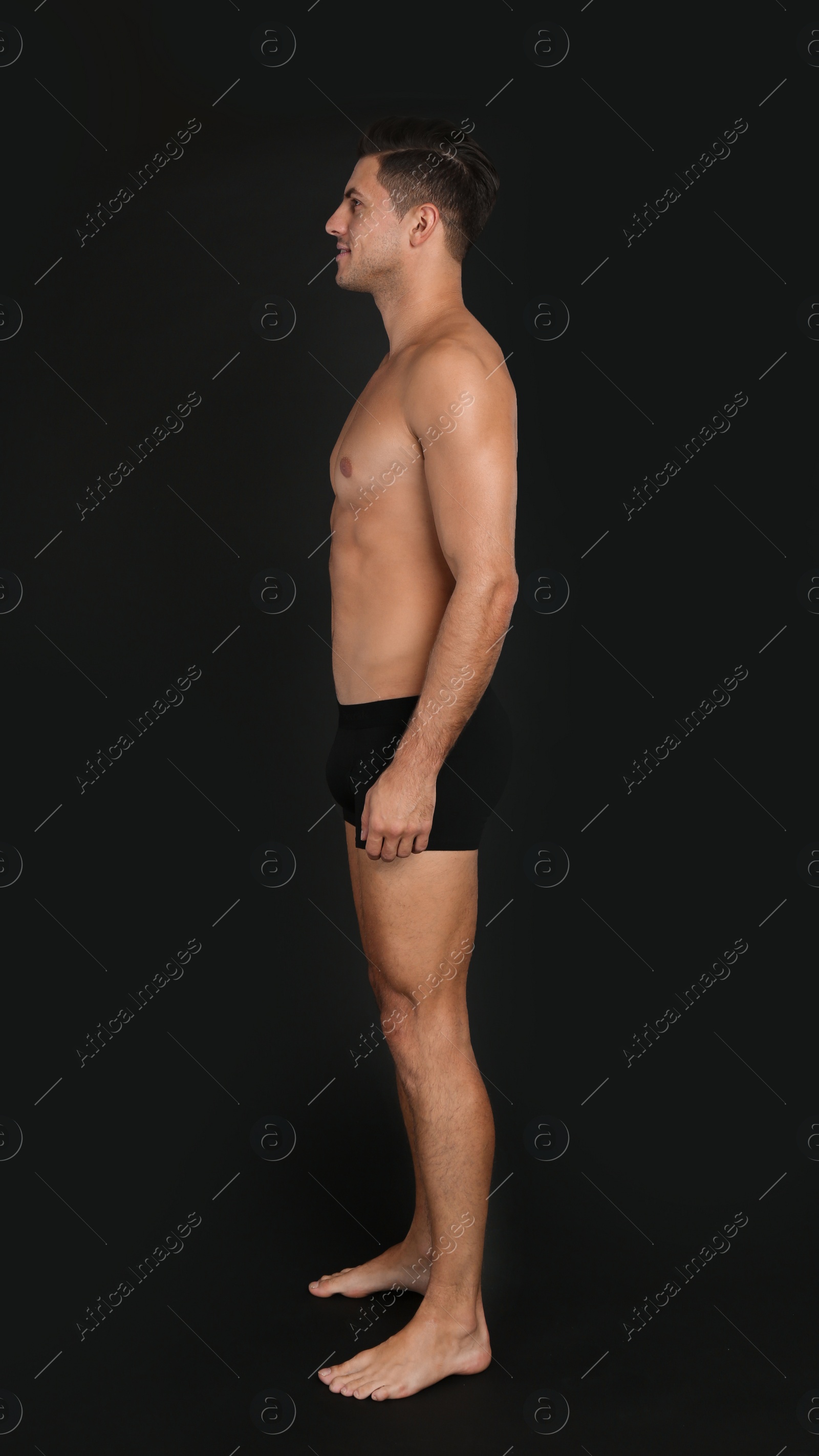 Photo of Handsome man in underwear on black background