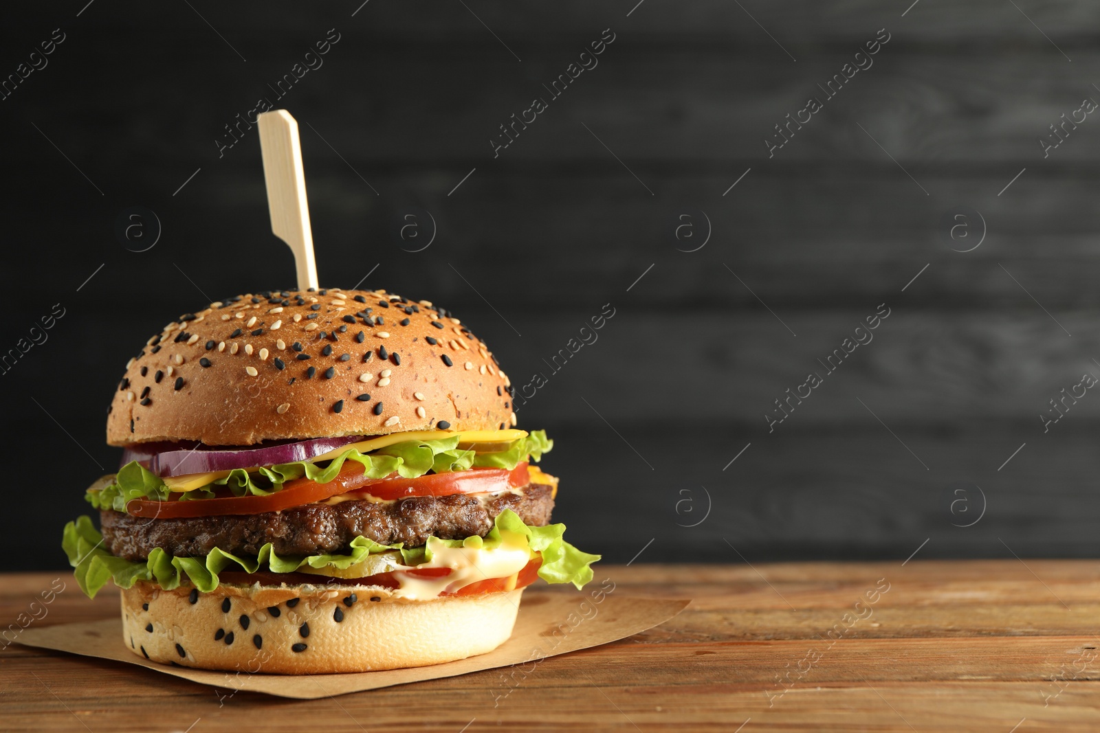 Burger with delicious patty on wooden table, space for text Photo of Burger with delicious patty on wooden table, space for text