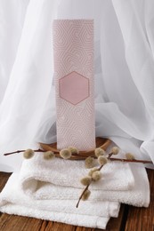 Photo of Scented sachet, pussy willow branches and towel on wooden table