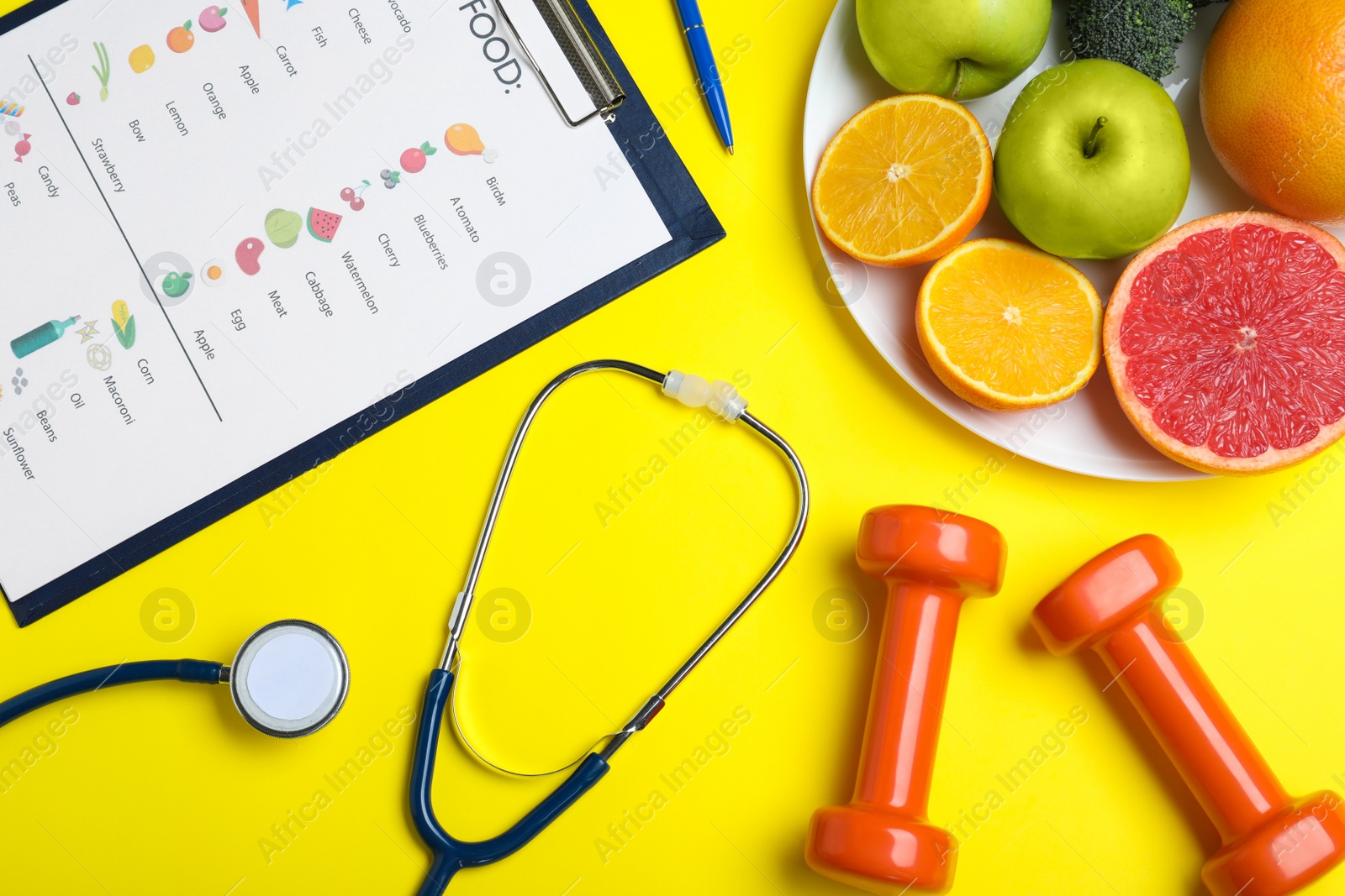 Photo of Fruits, dumbbells, stethoscope and list of products on yellow background, flat lay. Visiting nutritionist