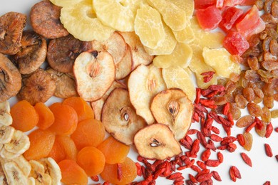 Pile of different tasty dried fruits on white background, top view