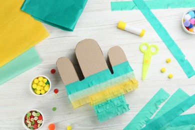 Photo of Cardboard cactus and materials on white wooden table, flat lay. Pinata DIY