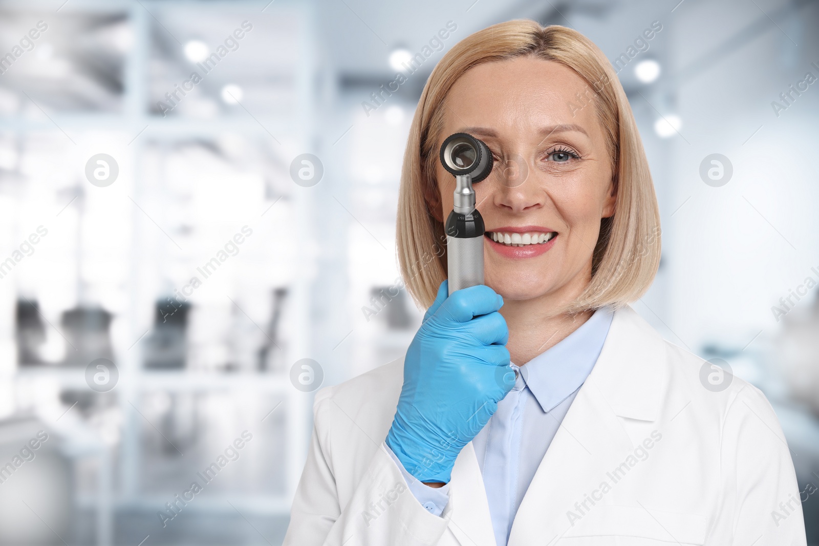Image of Professional dermatologist with dermatoscope on blurred background, space for text
