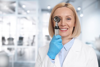 Image of Professional dermatologist with dermatoscope on blurred background, space for text